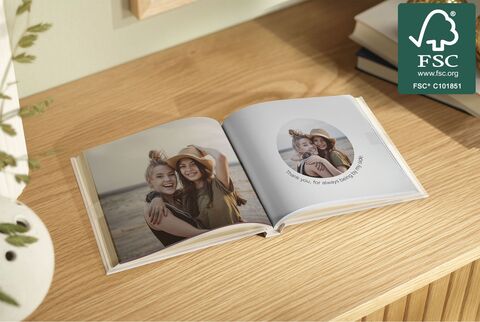 An open photo book on a wooden table showing memories.