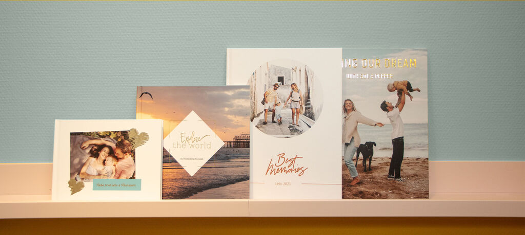 A selection of CEWE photo products on a shelf, including photo books and greeting cards.