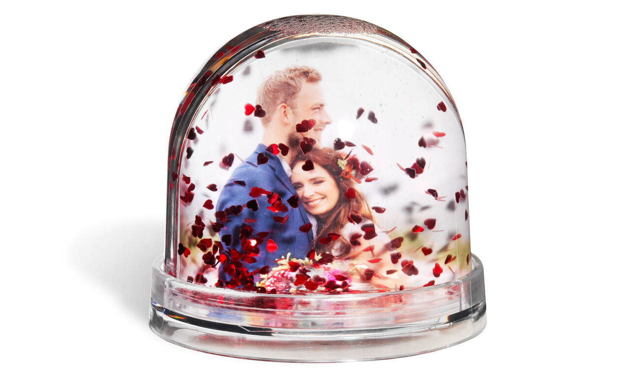 Wonderful snow globe with a loving couple and heart confetti.