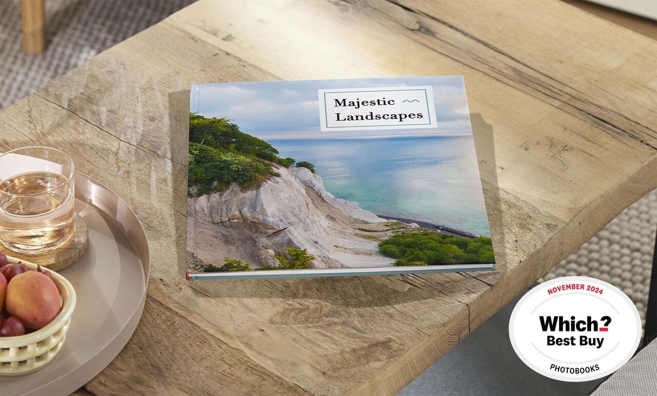 Photo book with impressive landscapes lies on a wooden table.