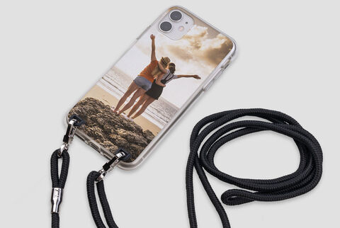 Two women standing on the beach enjoying the sunset, showing a personalized phone case with their image.
