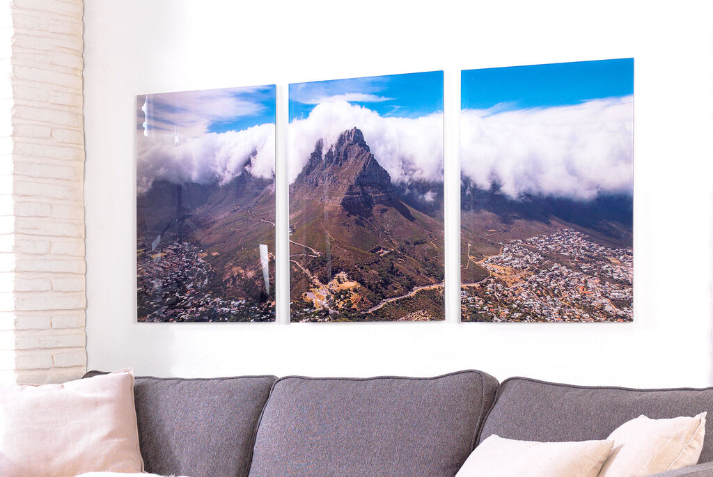 Three-part wall picture of a mountain with clouds in front of a city.