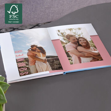 A happy couple in a photo book with vacation memories.