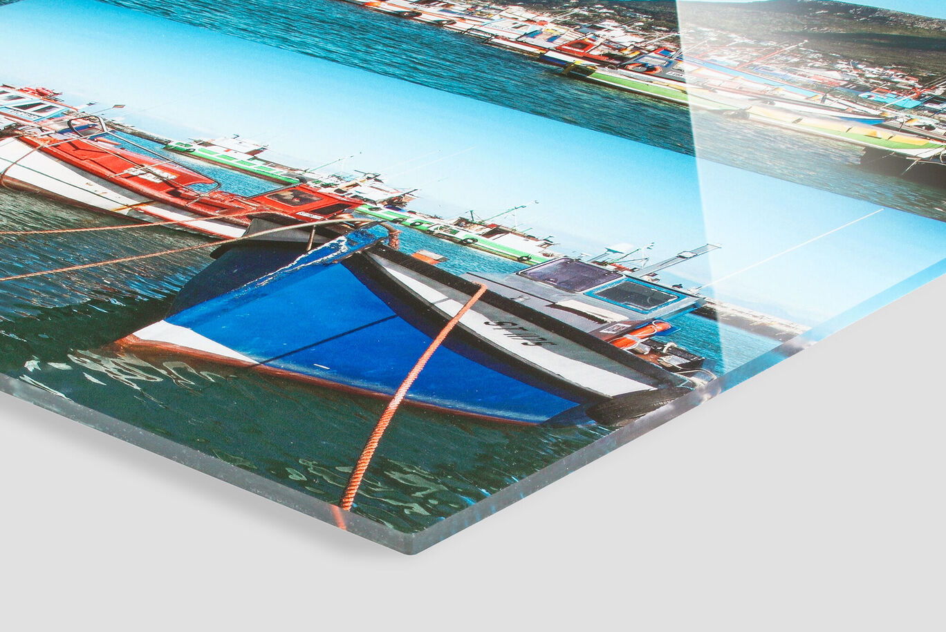 Colorful boats resting in clear water with sunshine and blue sky in the background.