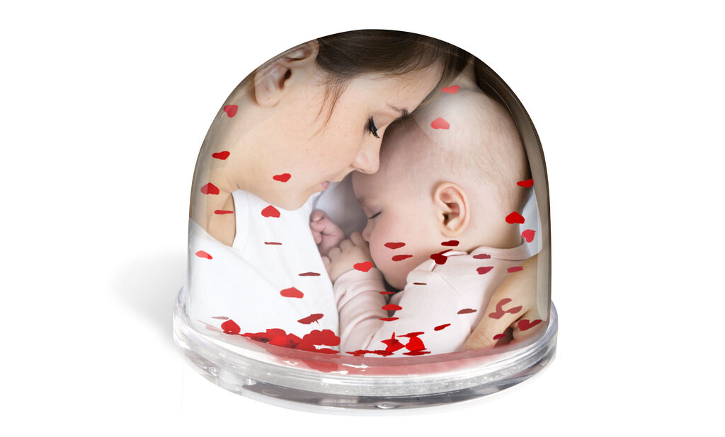 A loving snow globe with red hearts and a baby motif.