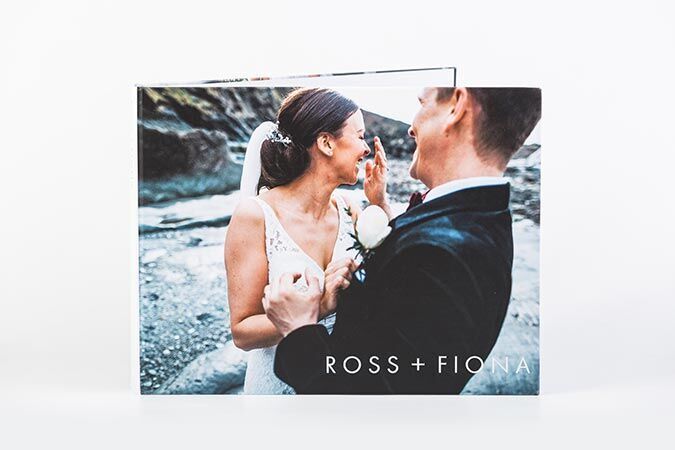 Bride and groom hold hands, radiating joy against a romantic nature backdrop, CEWE photo book