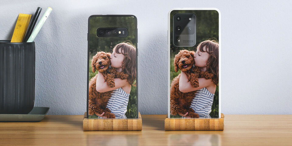 A happy girl hugs her dog while they stand together on a table