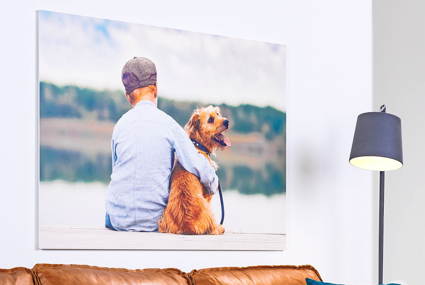 A child sits with their dog by the lake and enjoys the moment