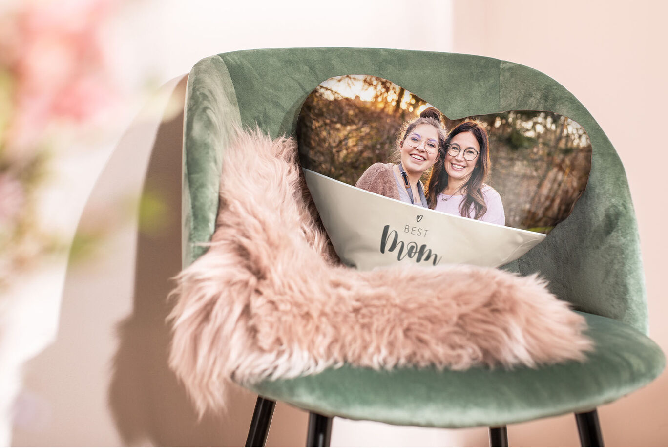 A heart-shaped photo card for the best mom on a green chair with a soft blanket