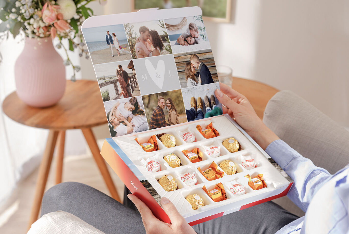 A person holds a CEWE greeting card box with pralines and personal photos.