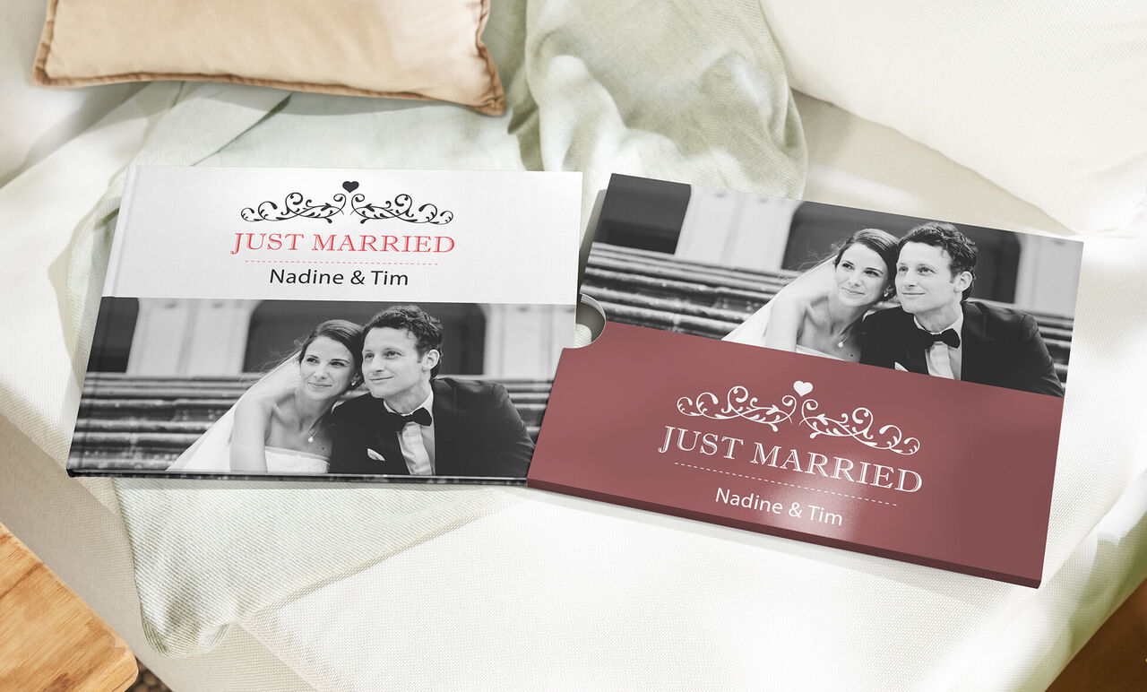 Two CEWE photo books titled 'Just Married' are on a table, surrounded by a cozy environment.