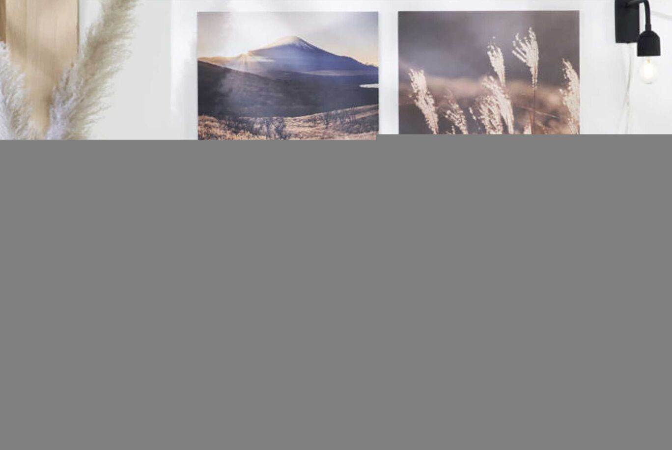 Wonderful landscape pictures on a wall with soft colors and a lamp in the room.
