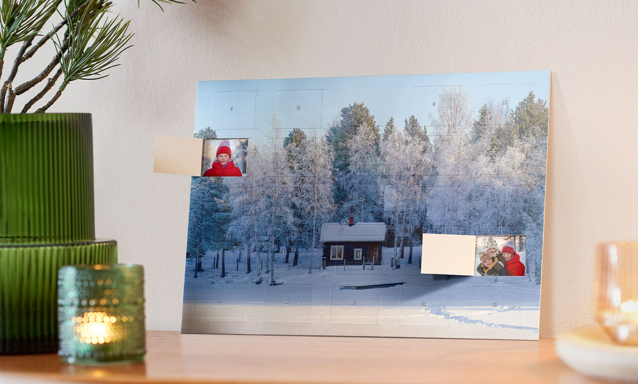 Winter landscape with a wooden house surrounded by snow-covered trees.