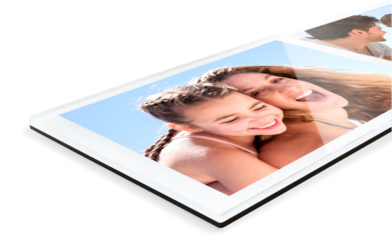 A mother and her daughter laugh together before a blue sky on a photo book.