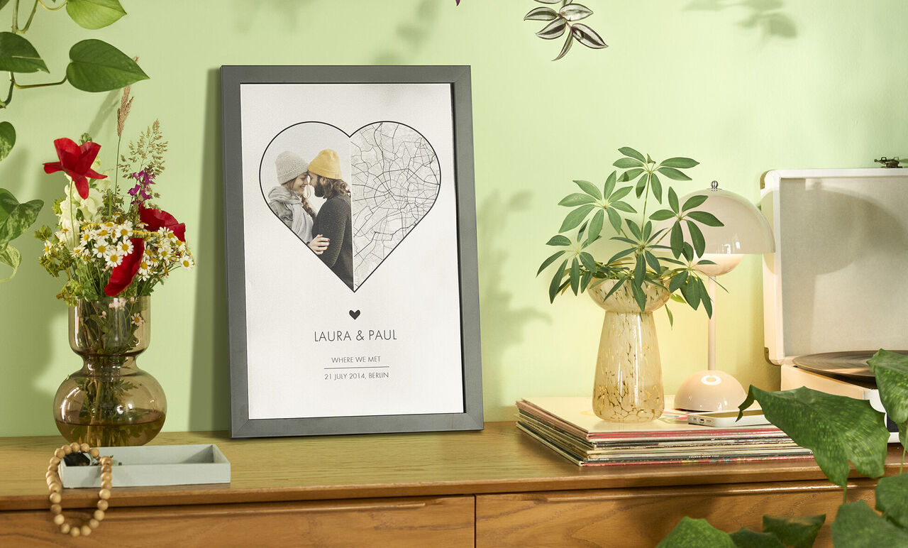 A loving heart-shaped wall picture with the names Laura and Paul, surrounded by plants and decor.