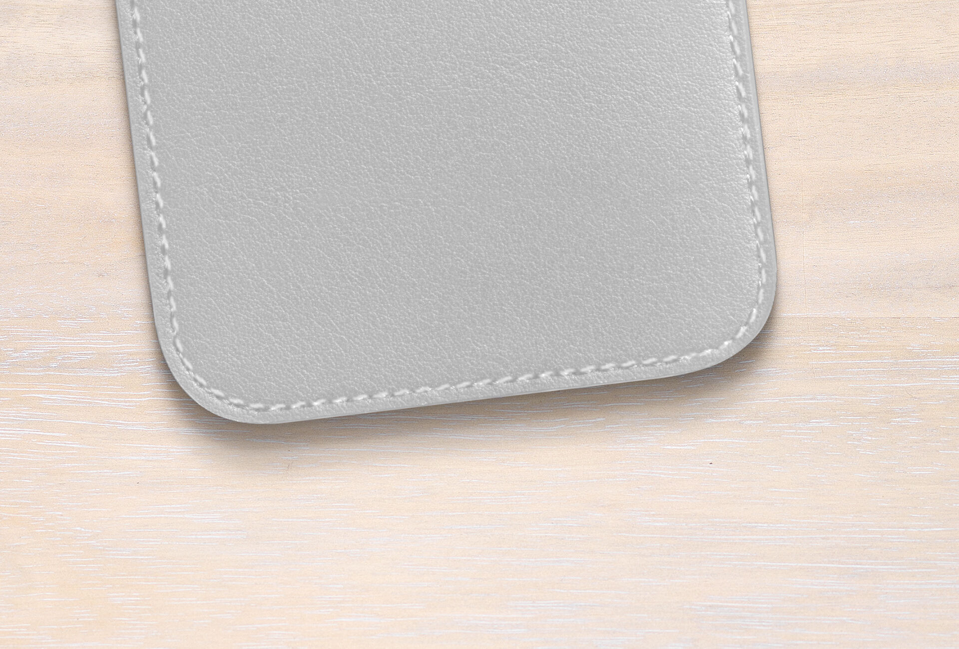 Gray genuine leather surface of the CEWE greeting card on light wood