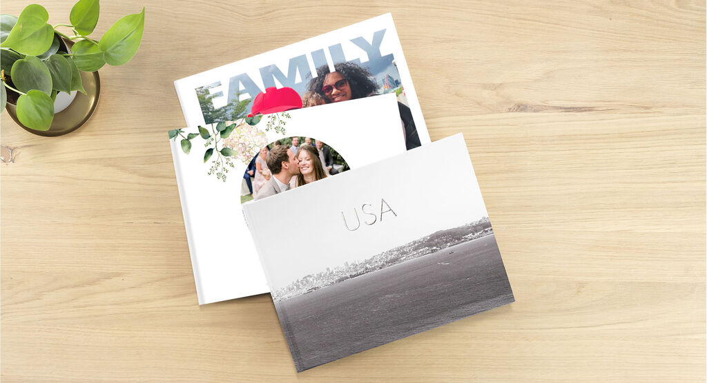 Three photo books lie on a table, one titled USA, another showing family photos.