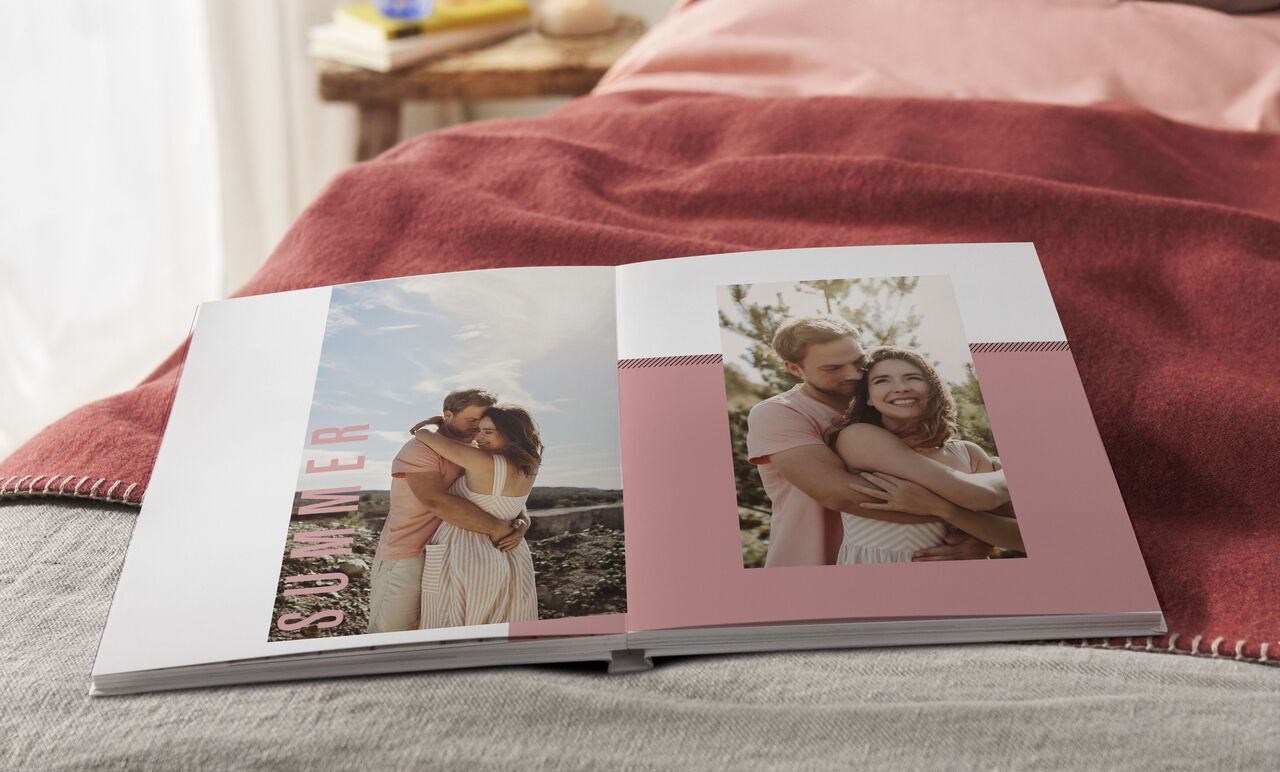 An open photo book on a bed with two pictures showing beautiful memories