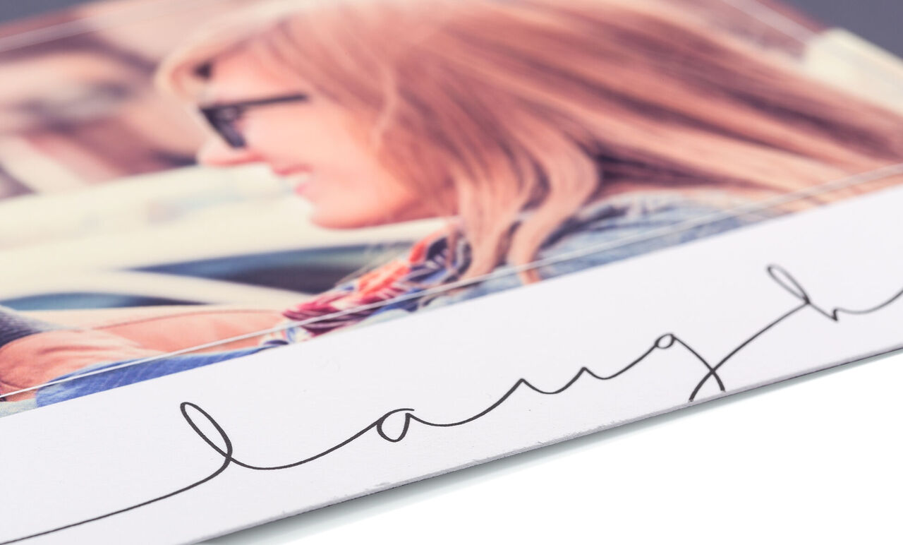 Close-up of a lovingly designed photo book with the word 'laugh' on the cover.