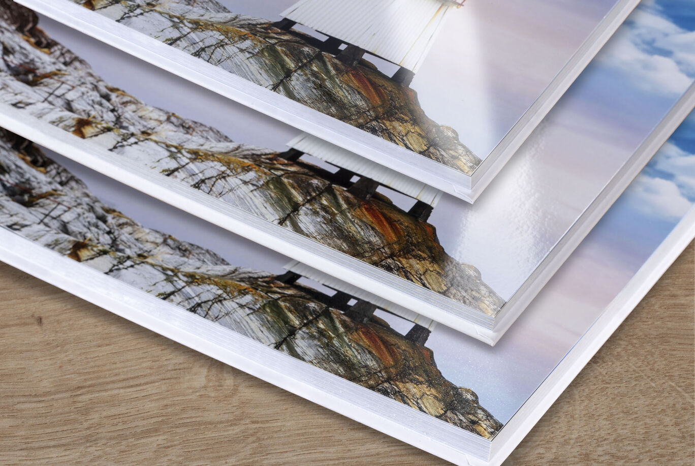 Three stacked photo books with beautiful landscape photos.