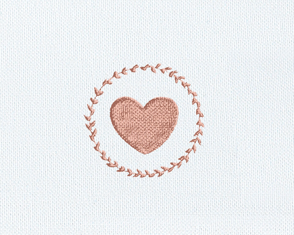 A heart-shaped embroidery in a round frame.