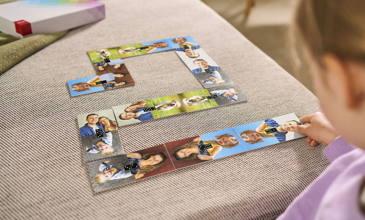 A child plays with a photo puzzle featuring various personal photos.