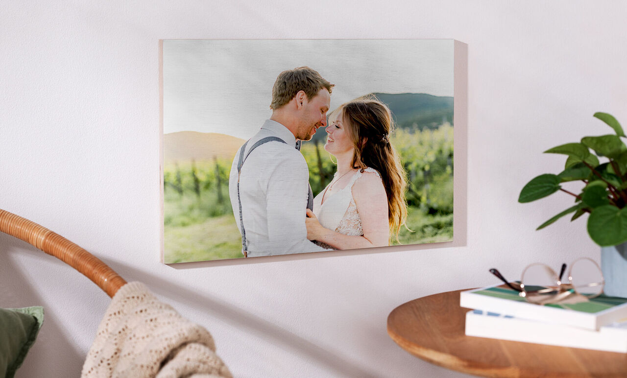 A loving couple stands in a picturesque landscape, surrounded by green. The sun shines over gentle hills