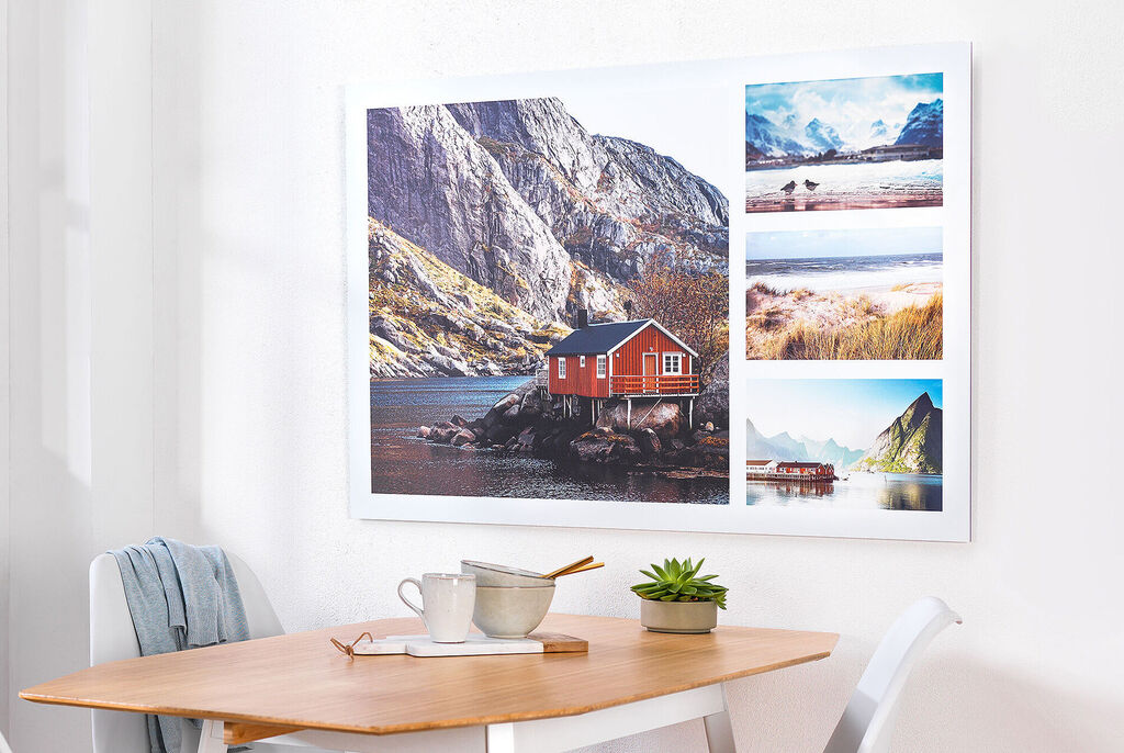 Cozy wall picture with a red cabin by the water and several landscape photos.