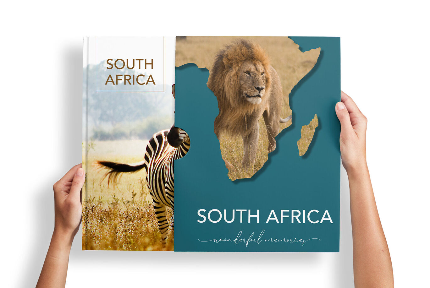 Two hands hold a CEWE PHOTOBOOK with a lion and zebra illustration in a stylish cover.