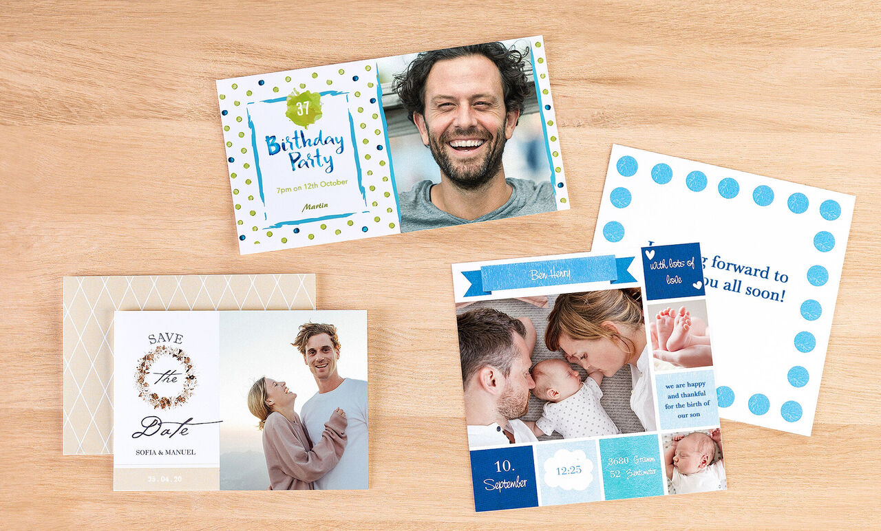 A beautiful set of CEWE greeting cards lying on a bright wooden table. One card says 'Birthday Party' and another has a Save-the-Date motif. Two photos show a family enjoying time together.