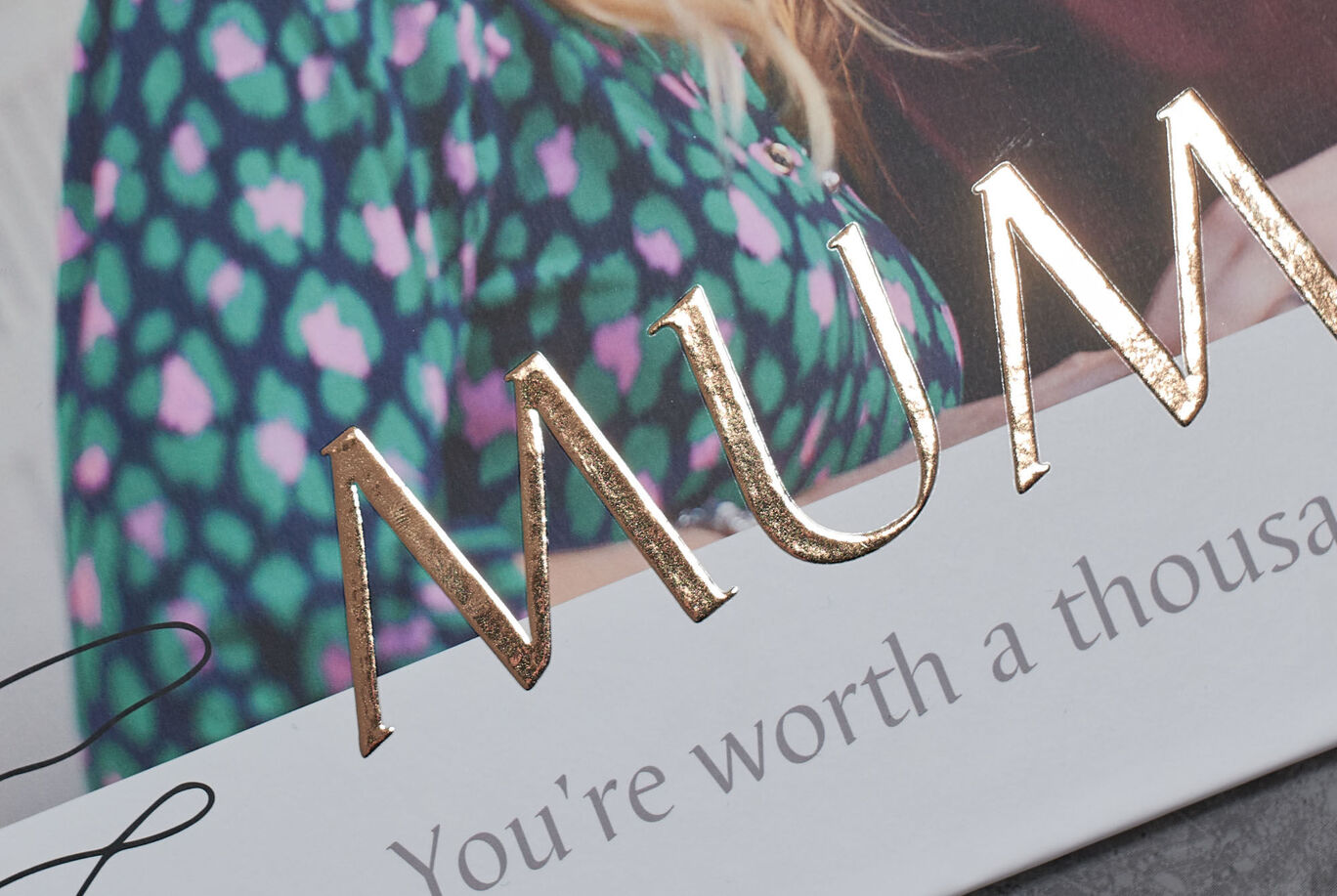 A glittering inscription of the word "MUM" on a lovingly designed greeting card.