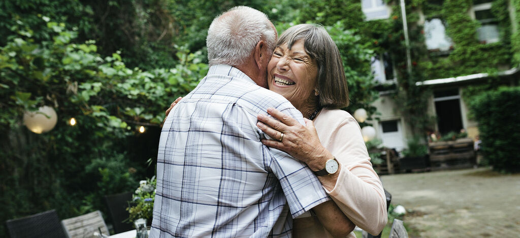 A loving couple embraces in a lovingly designed garden.