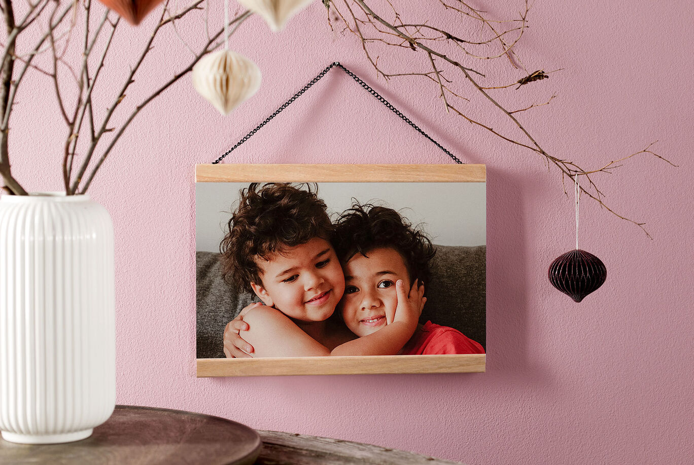 A loving photo of two children hugging, in a stylish frame on a wall. Elegant decor is visible in the background.