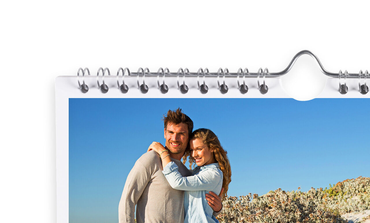 A couple happily embracing in front of a blooming landscape