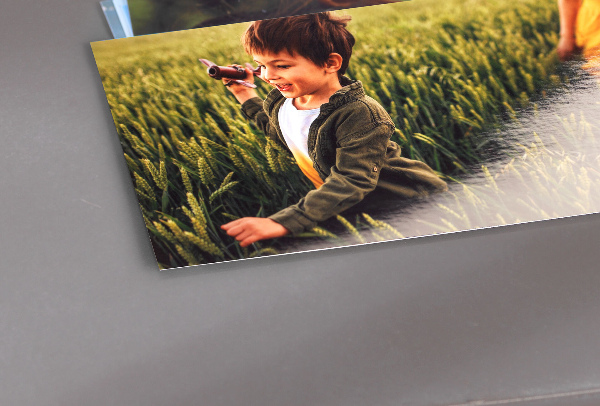 A child in a field searching for something with a toy camera