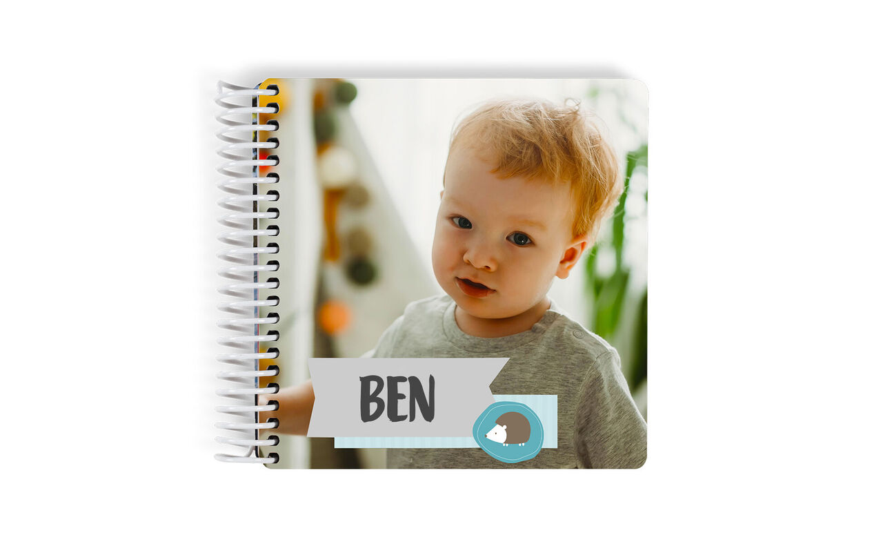 An open CEWE photo book with the name Ben on the cover and a cheerful layout