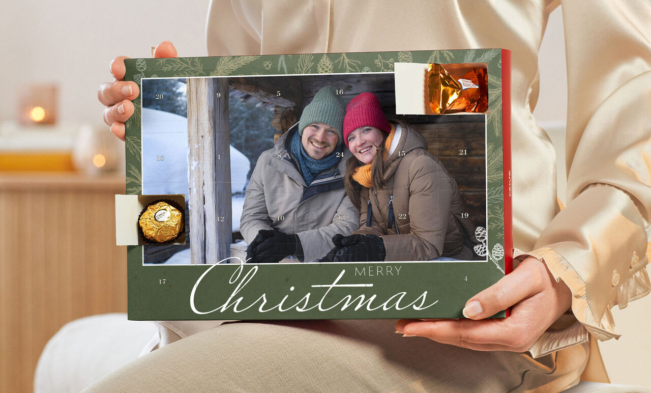 A person holds a festive Advent calendar with loving design and little surprises in hand