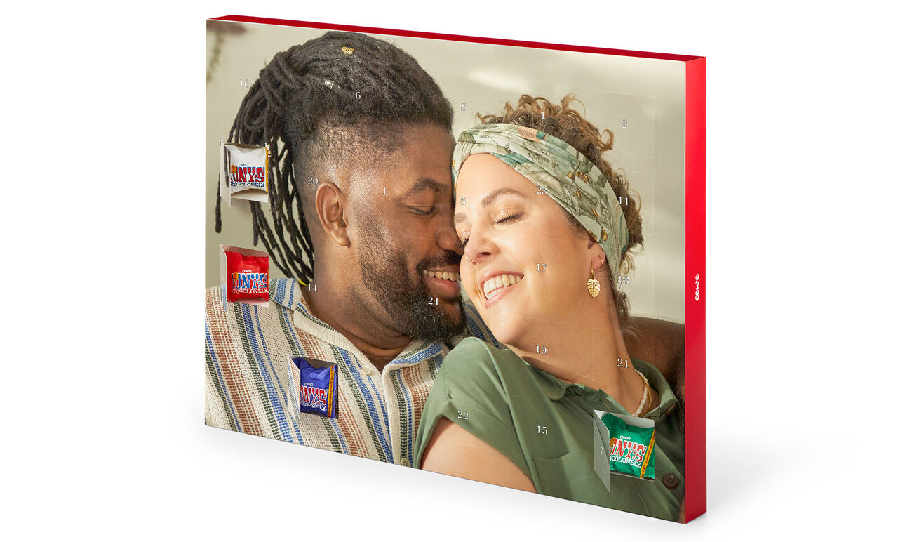 Two people lovingly on a couch surrounded by CEWE products.