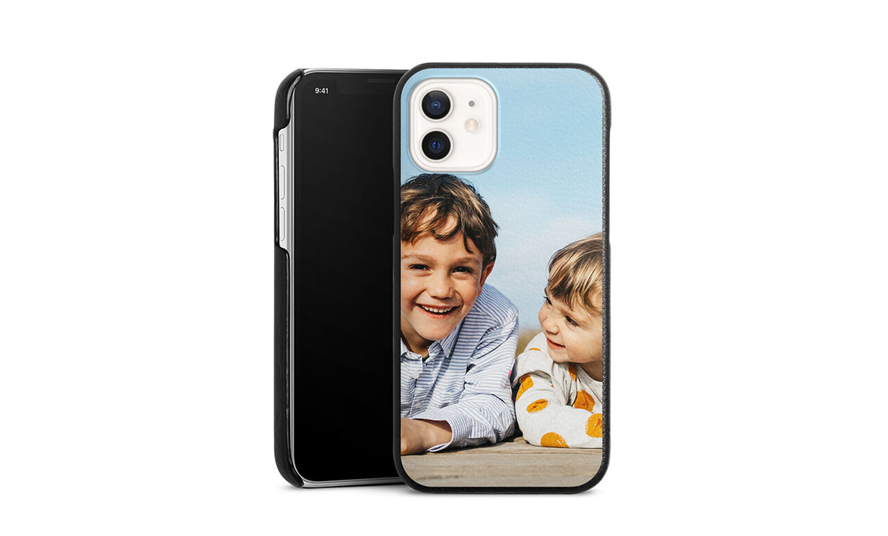 Two people relax on the beach with a smartphone. Father and daughter enjoy quality time together.
