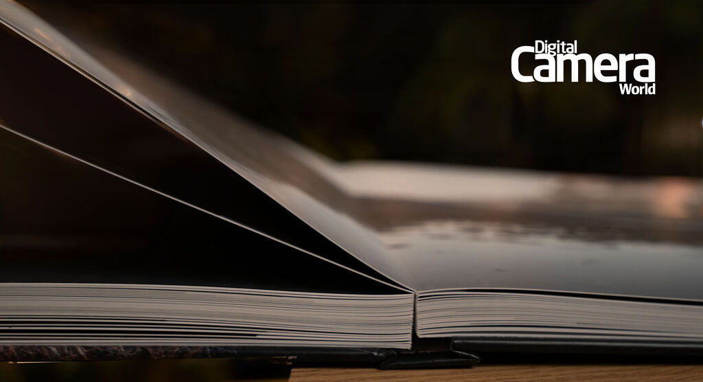 The edge of an open photo book shows its smooth binding and pages ready to be flipped through.