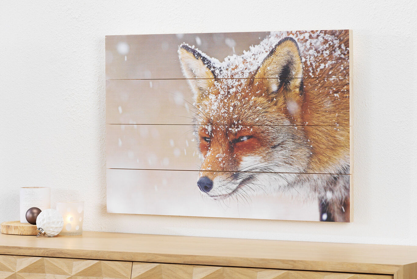 A creative wall picture of a snow-covered fox, hanging in a bright room.