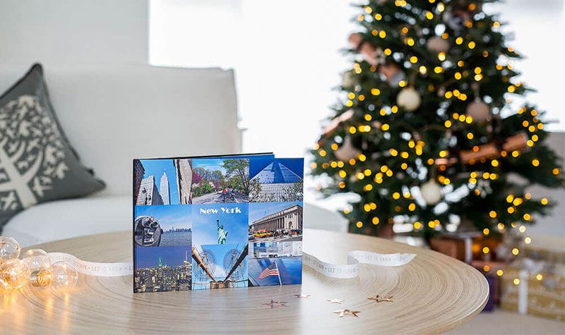 CEWE photo book with various vacation memories in front of a Christmas tree.