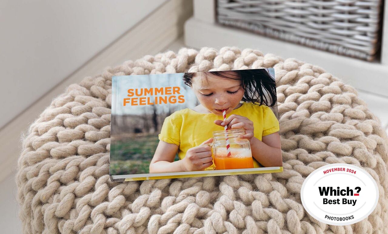 A creative photo book titled 'Summer Feelings'. A child drinks from a glass. The background shows a cozy environment.