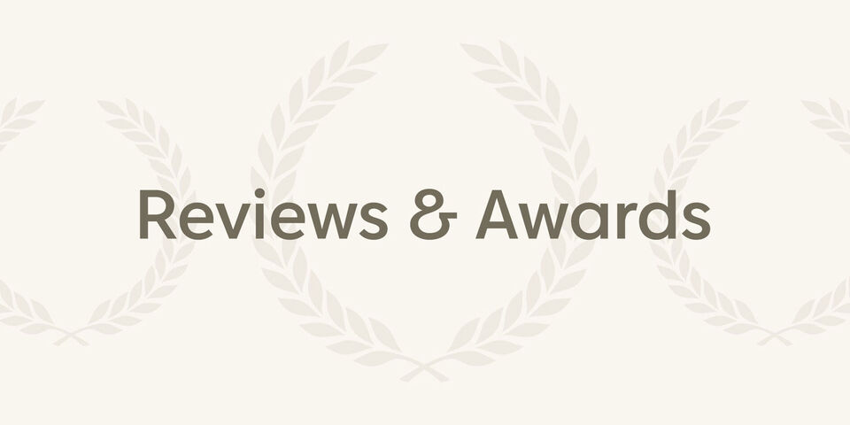 The words 'Reviews & Awards' framed by a floral pattern with laurel leaves
