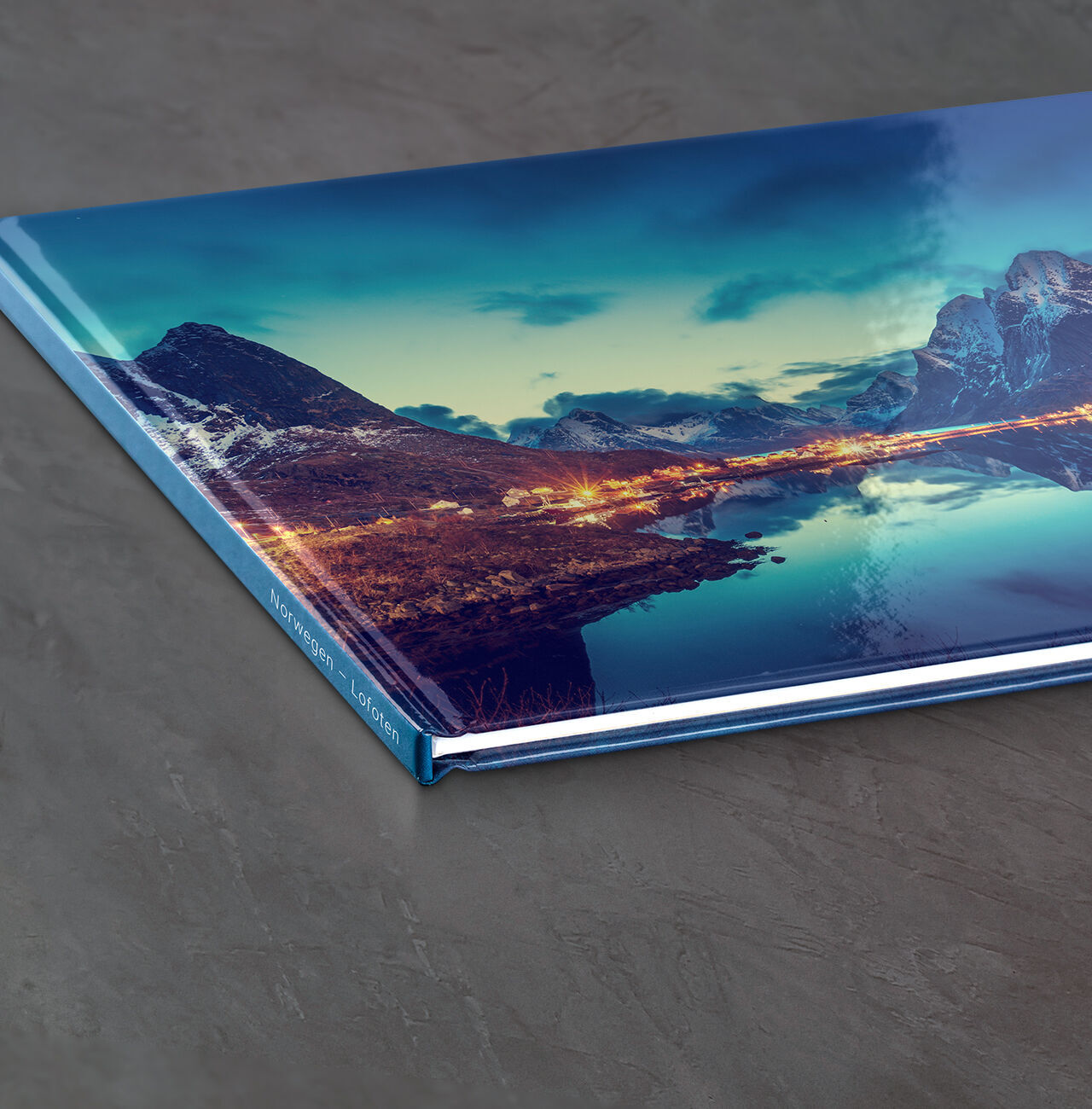 The CEWE PHOTO BOOK shows a stunning landscape with mountains and a calm lake, perfect for memories.
