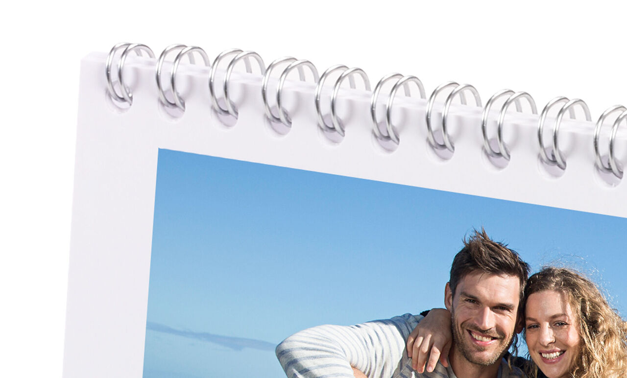 A happy couple takes a snapshot by the coast.