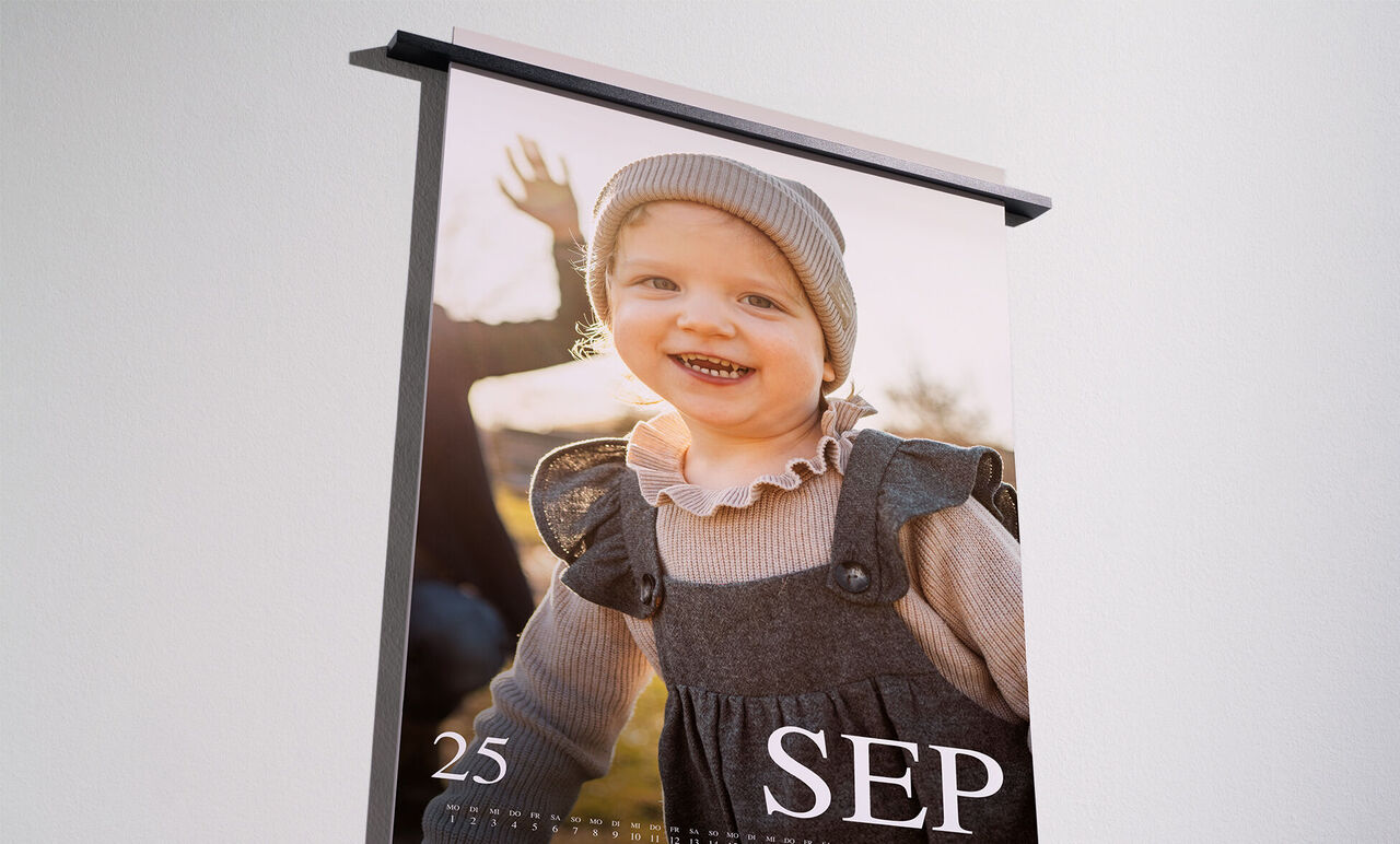 A lovingly designed photo calendar with an image of a happy child outdoors smiling at the camera.
