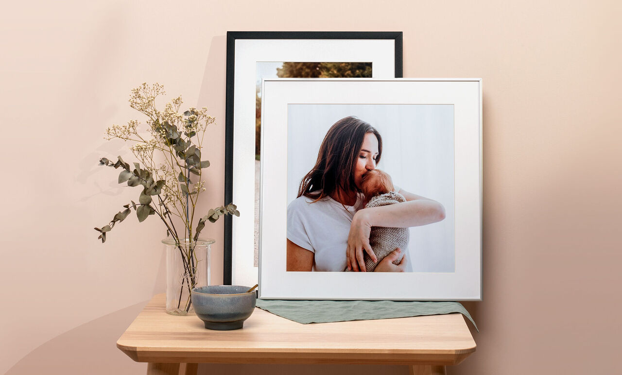 A framed picture of a person with a pet, decorated with a flower and a bowl.