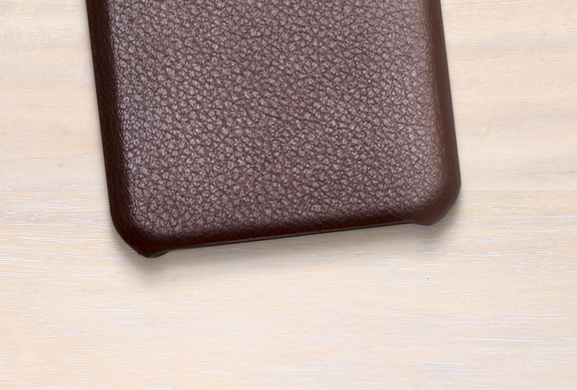Brown leather case on light wood background