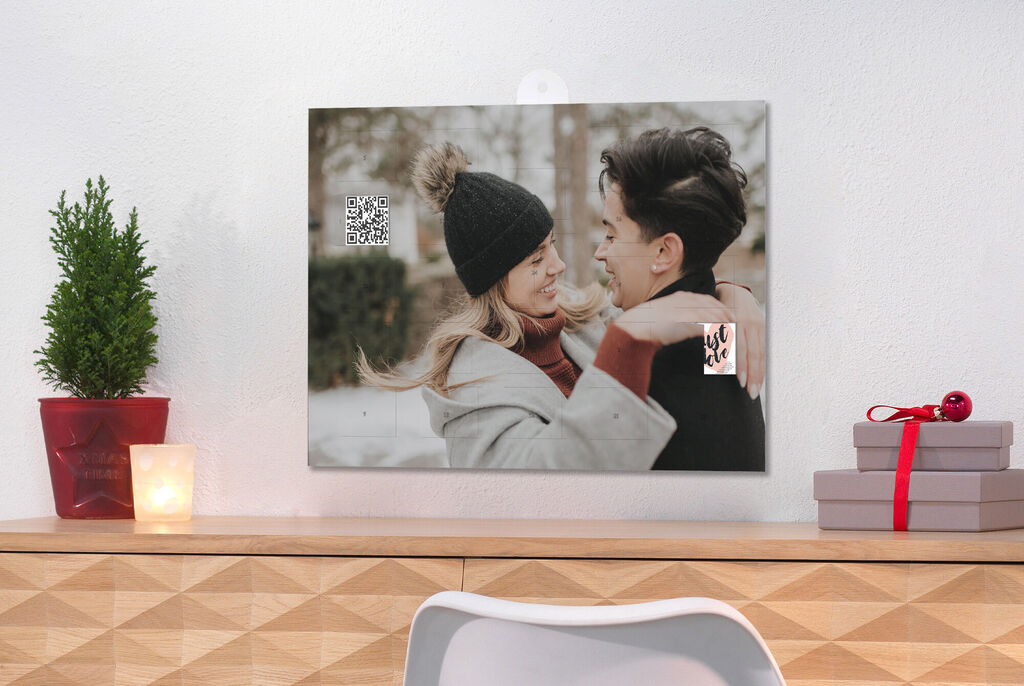 A heartfelt moment between two people in winter clothing against a snowy backdrop. A plant and decor on the table.